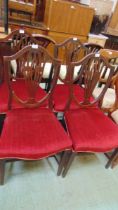 A set of four mahogany shield back dining chairs, early 19th century, with stuff over seats, on