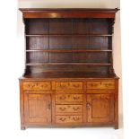 A George III oak Welsh dresser, with cavetto moulded pediment above the boarded back with three