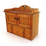 An early 20th century table top oak cabinet, with blind gallery above two cupboard doors and eight