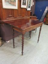 A 19th century mahogany swivel top table on barley twist supports