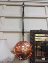 A brass and copper bed warming pan