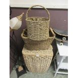 A wicker linen basket together with two seagrass baskets