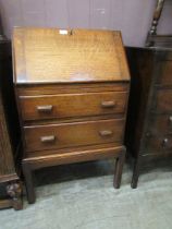 A mid-20th century oak bureau having fall above two drawers