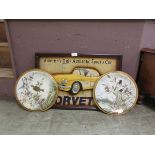 A pair of tin wall plates with bird design together with a reproduction framed model of a Corvette