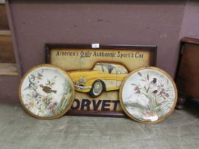 A pair of tin wall plates with bird design together with a reproduction framed model of a Corvette