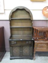 A reproduction dark oak Dutch dresser, having an arch top plate rack, the base having drawer over