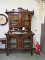 An Edwardian mahogany inlaid cabinet having a two door glazed top section, the base having two