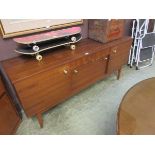 A mid 20th century teak veneered sideboard, having a centre drawer above pull down front, being