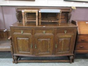 A mid 20th century oak sideboard, having three drawers over three carved doors
