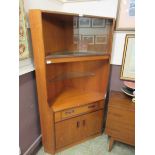 A mid 20th century teak full height corner cabinet, having a glazed top section, the base having