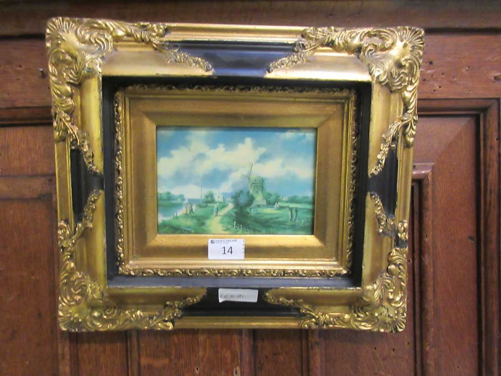 An ornate gilt framed oleograph of windmill scene