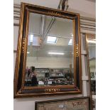 A large modern and gilt framed rectangular wall mirror