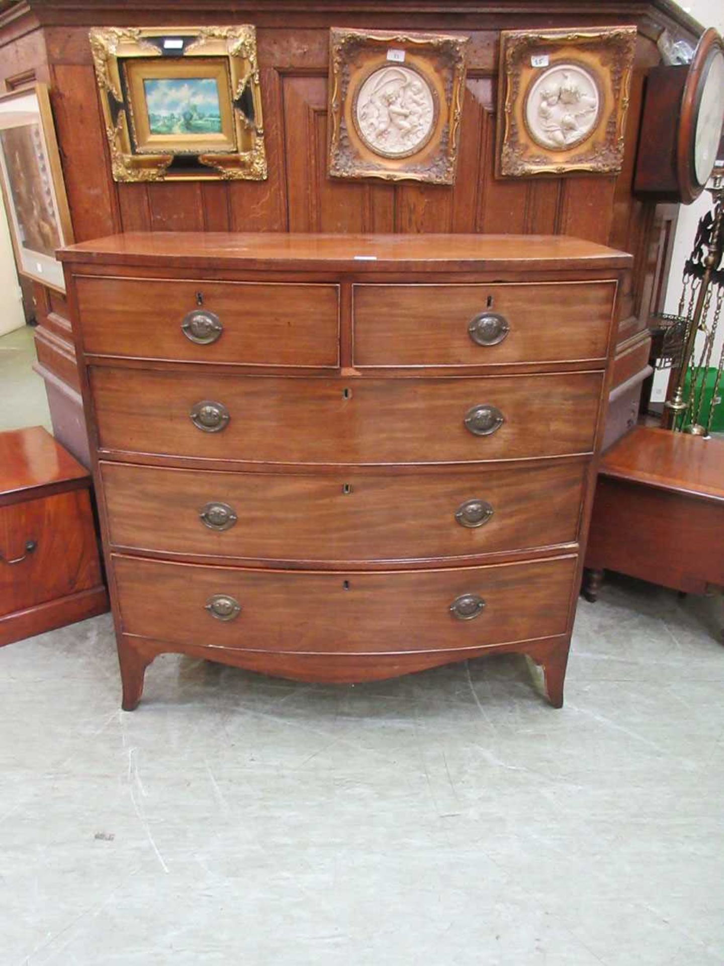 A Georgian mahogany bow front chest of five drawers on splay feet