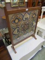 A mahogany framed framed fire screen, with crewel work panel