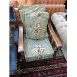 A 1950s oak framed easy chair with green floral upholstery