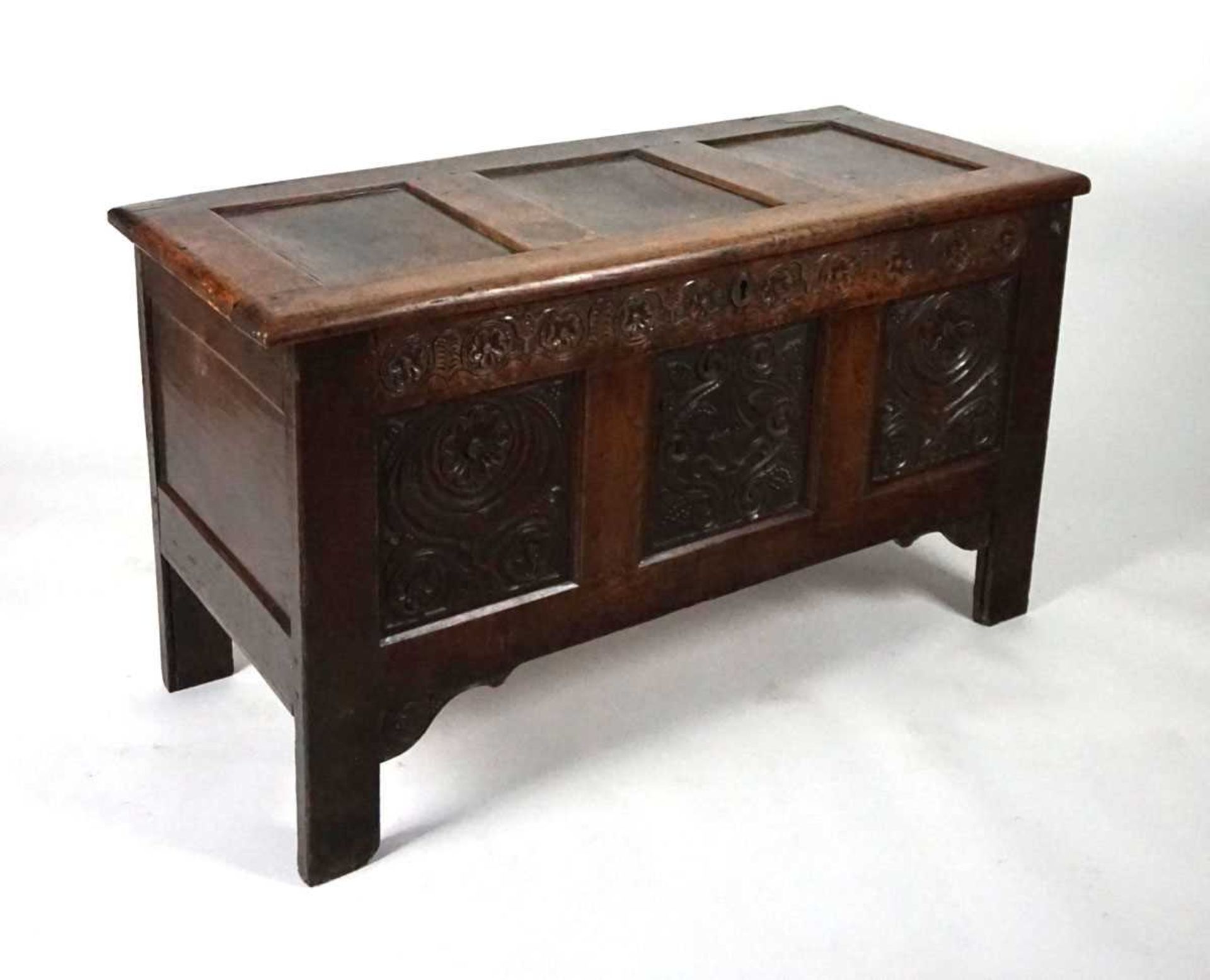 An 18th century oak coffer, the top with three recessed panels, above a carved frieze of roses and - Image 8 of 9