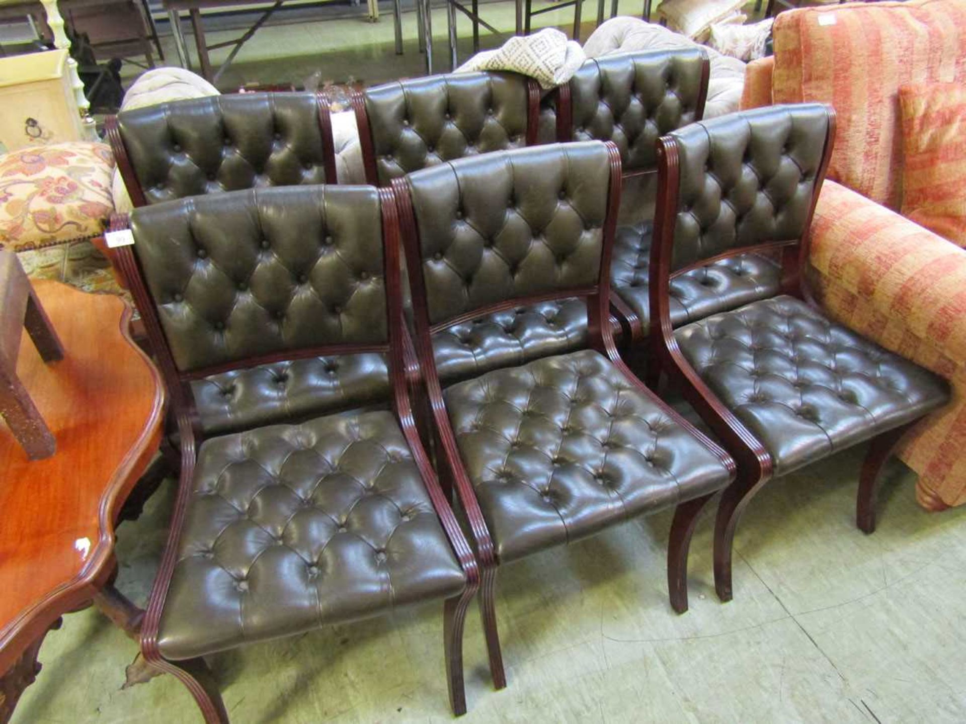 A set of six reproduction Regency mahogany sabre leg chairs upholstered in buttoned leather