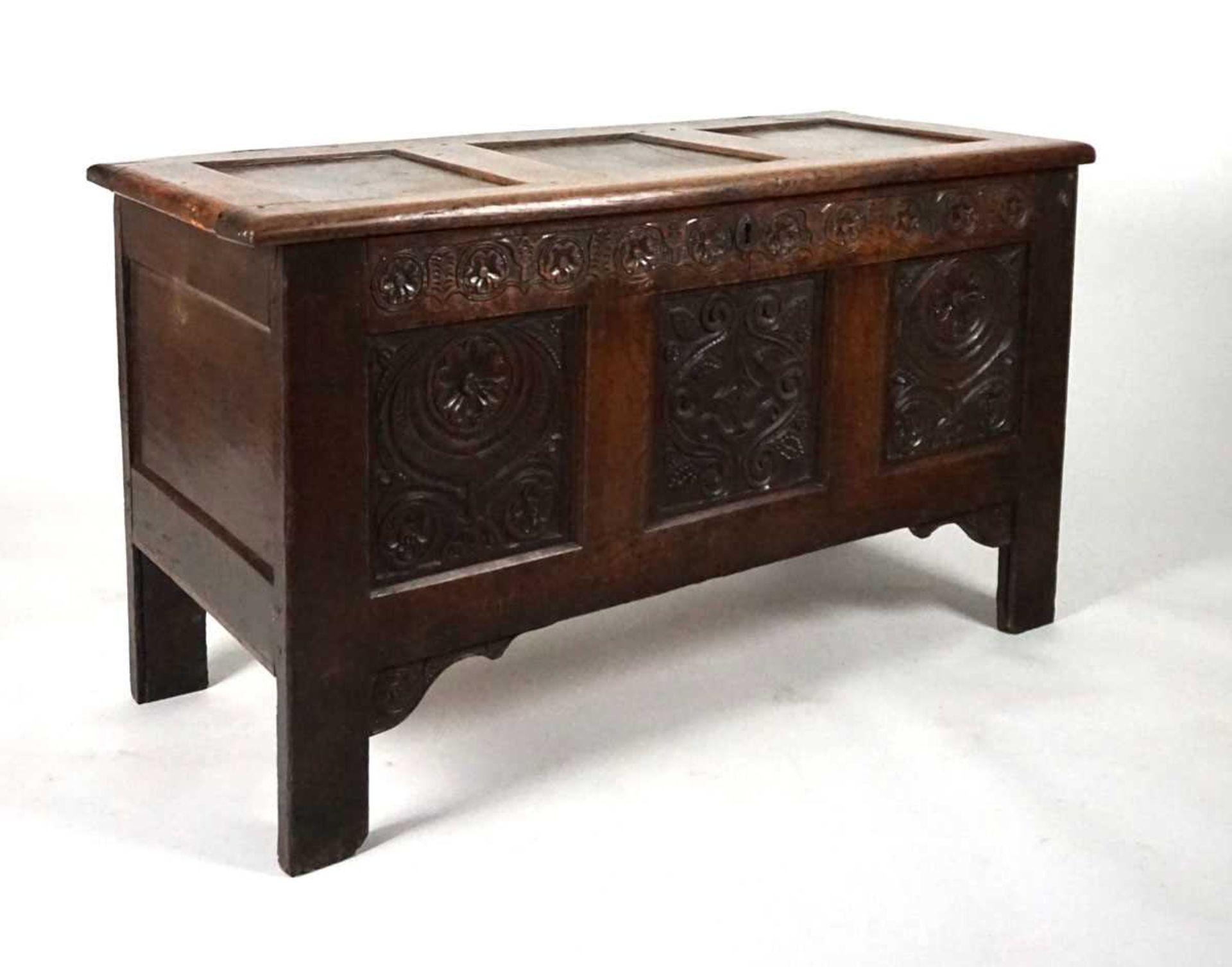 An 18th century oak coffer, the top with three recessed panels, above a carved frieze of roses and - Image 9 of 9