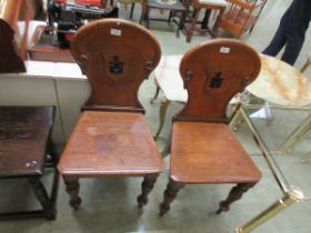 A pair of Victorian oak hall chairs