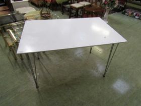 A modern white and chrome legged rectangular table