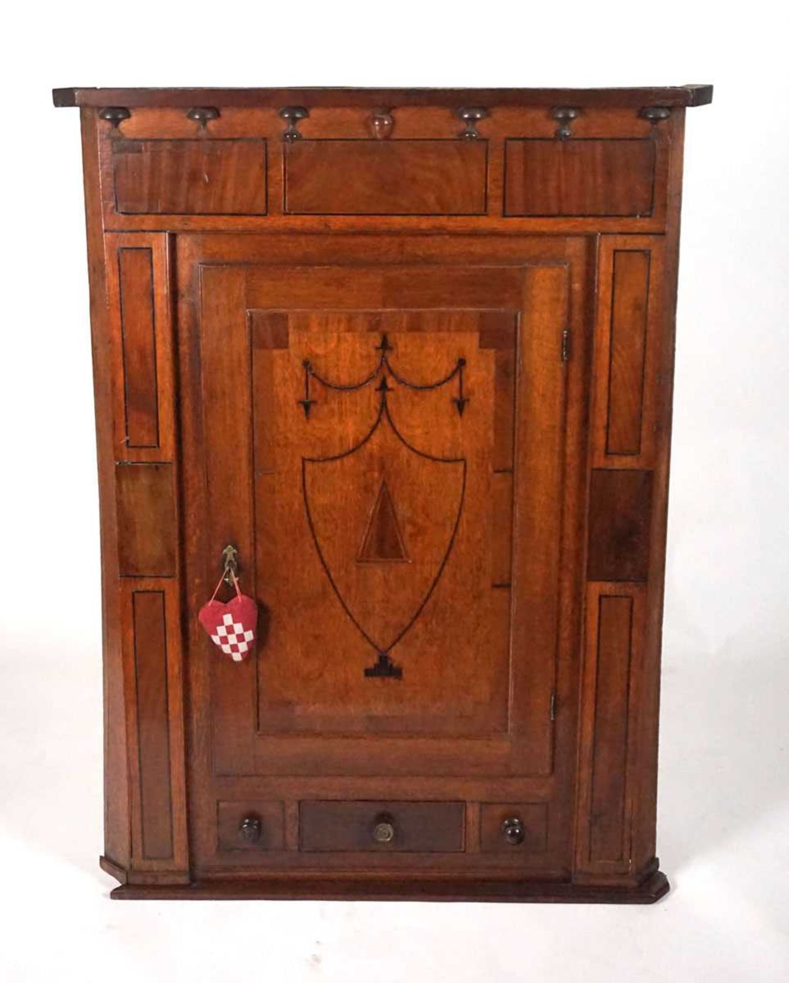 A provincial 19th century oak wall mounted corner cupboard, the door with inlaid ebony shield