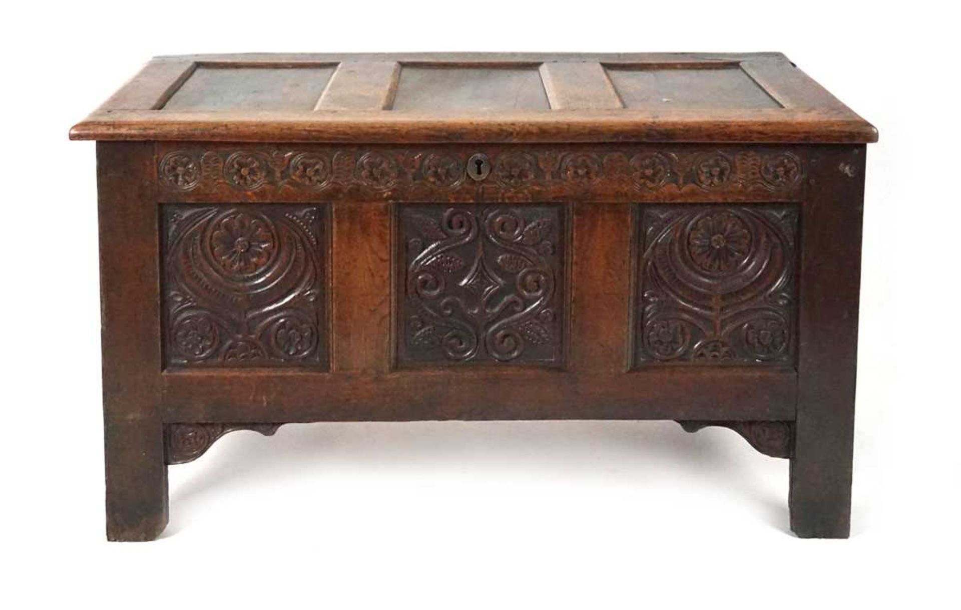 An 18th century oak coffer, the top with three recessed panels, above a carved frieze of roses and