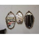 A set of three oval gilt framed mirrors