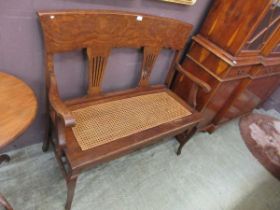 An early 20th century oak and bergere two seater settle