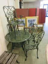 A cast metal circular garden table together with a set of four matching chairs