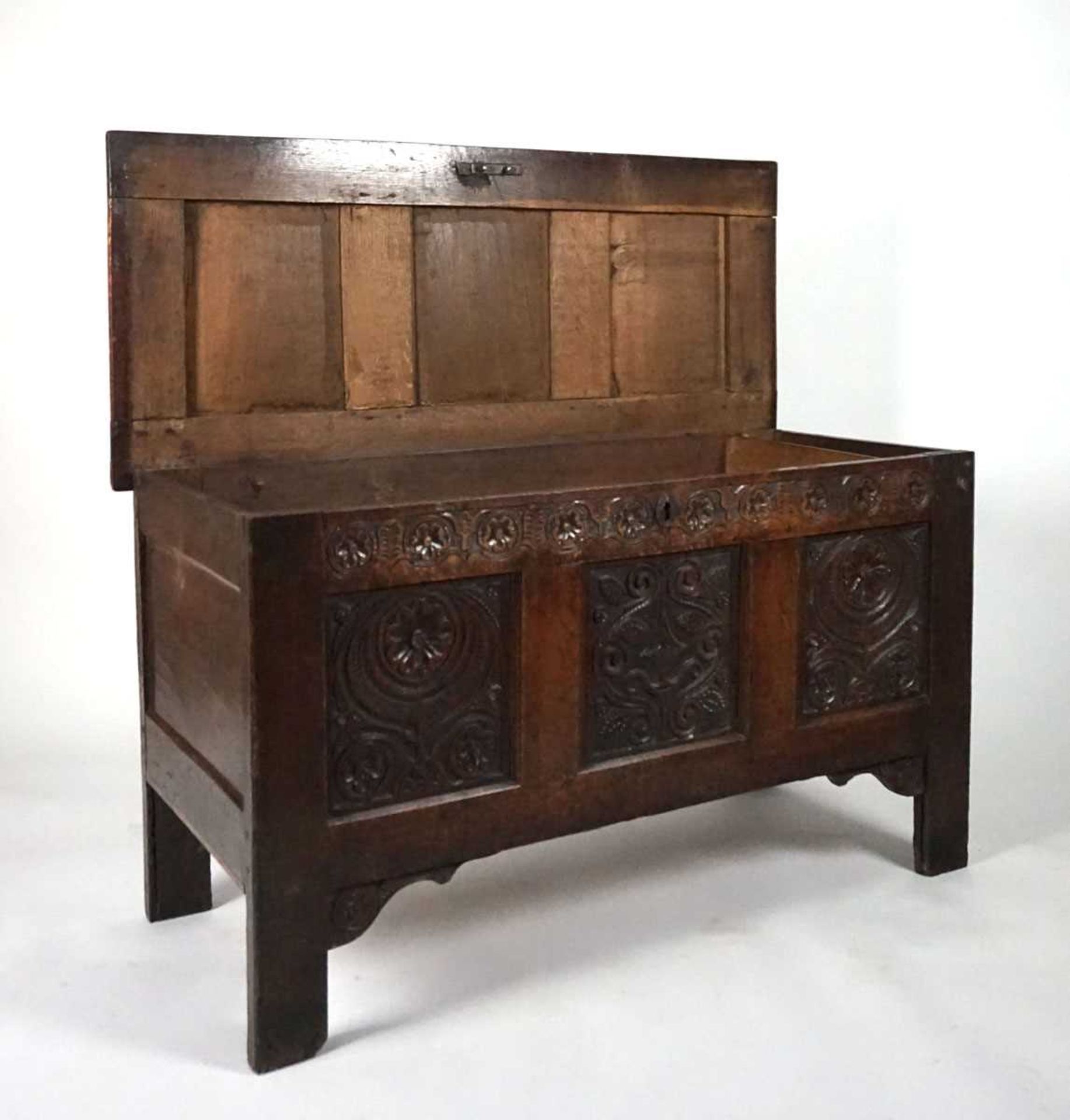 An 18th century oak coffer, the top with three recessed panels, above a carved frieze of roses and - Image 7 of 9