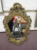 A modern ornate gilt framed wall mirror