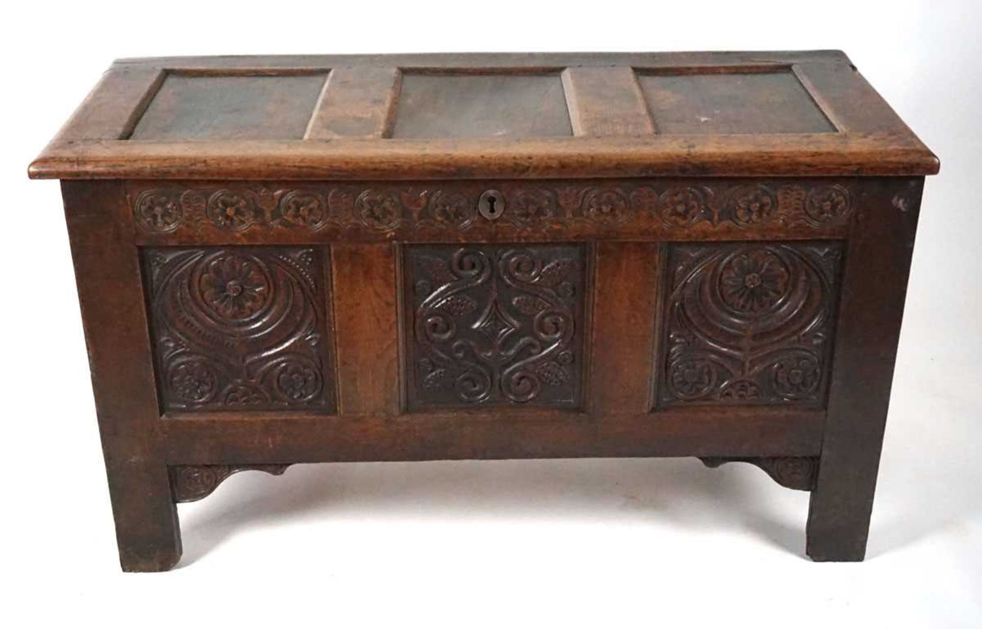 An 18th century oak coffer, the top with three recessed panels, above a carved frieze of roses and - Image 3 of 9