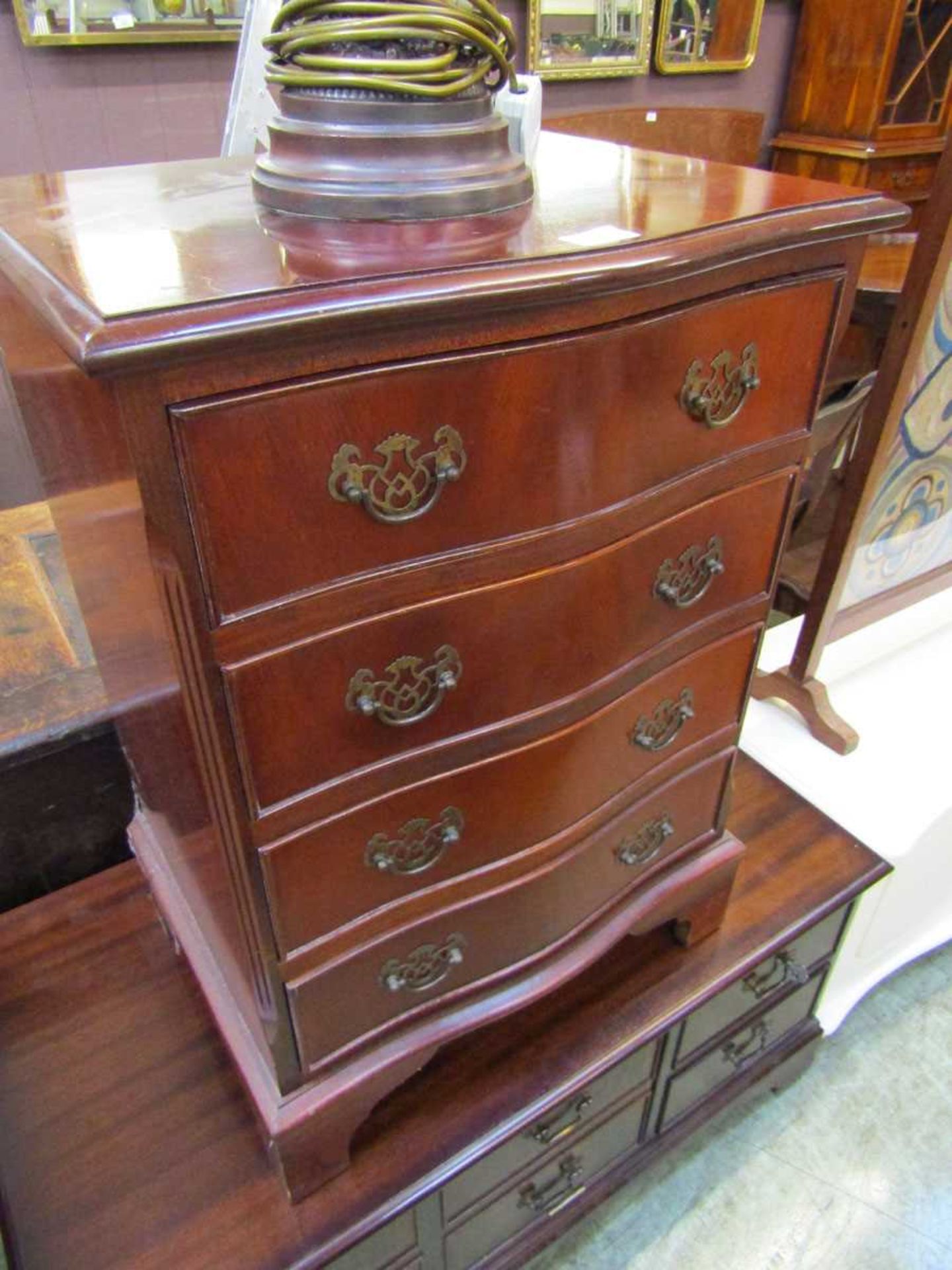 A reproduction serpentine fronted chest of four drawers