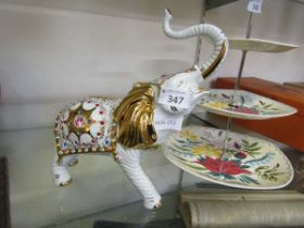 A gilt and white decorated ceramic figure of an elephant by Limoges and Swarovski