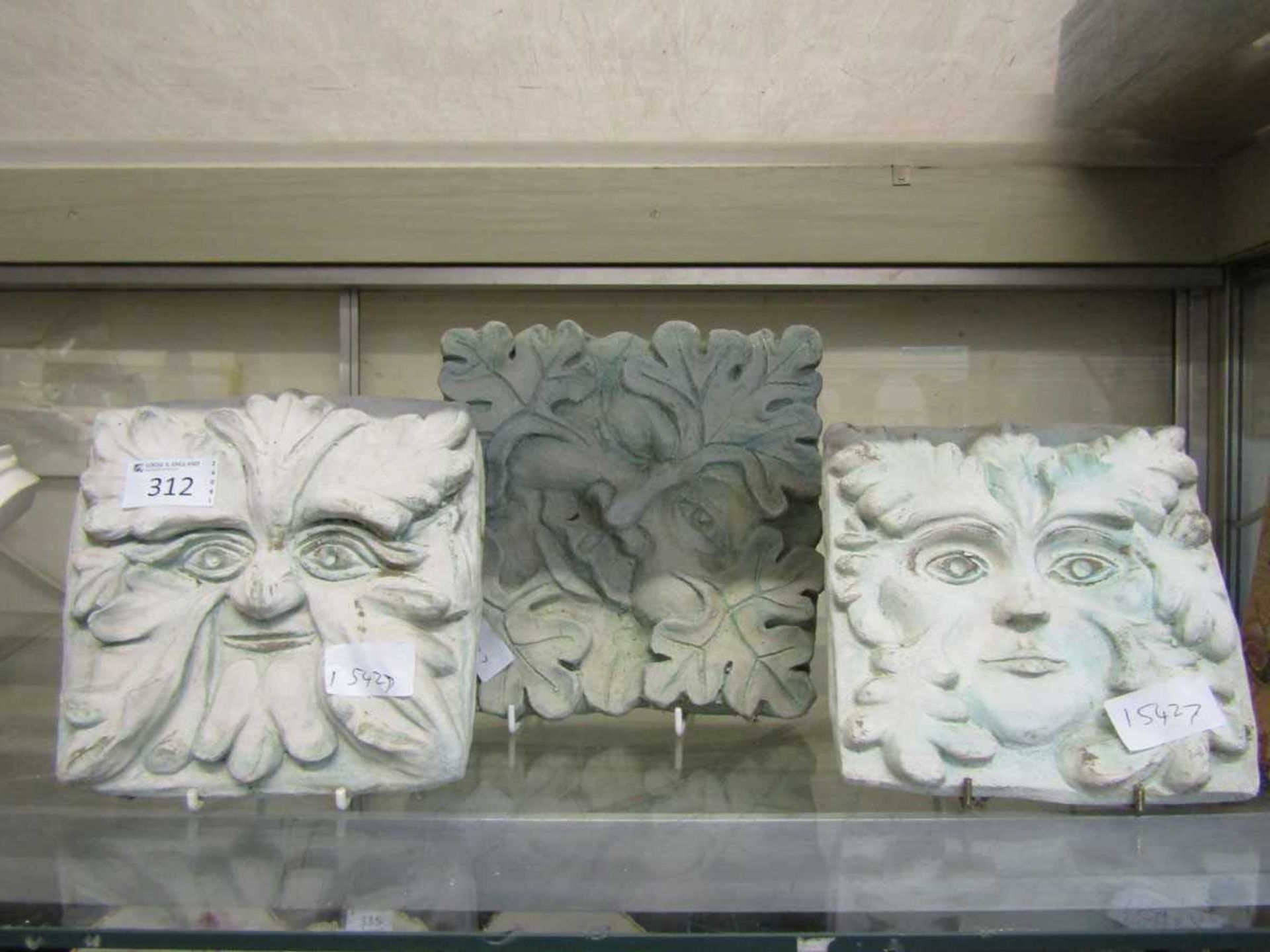 Three painted stoneware 'Green Man' plaques