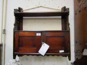 An early 20th century stained wooden two door wall mounted cupboard with shelf