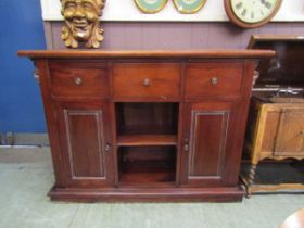A late Victorian mahogany sideboard having three drawers above open storage flanked by cupboard