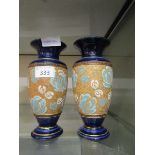 Two blue ground Royal Doulton urns with embossed floral decoration