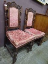 A pair of Edwardian carved oak hall chairs