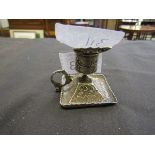 A small white metal embossed candlestick