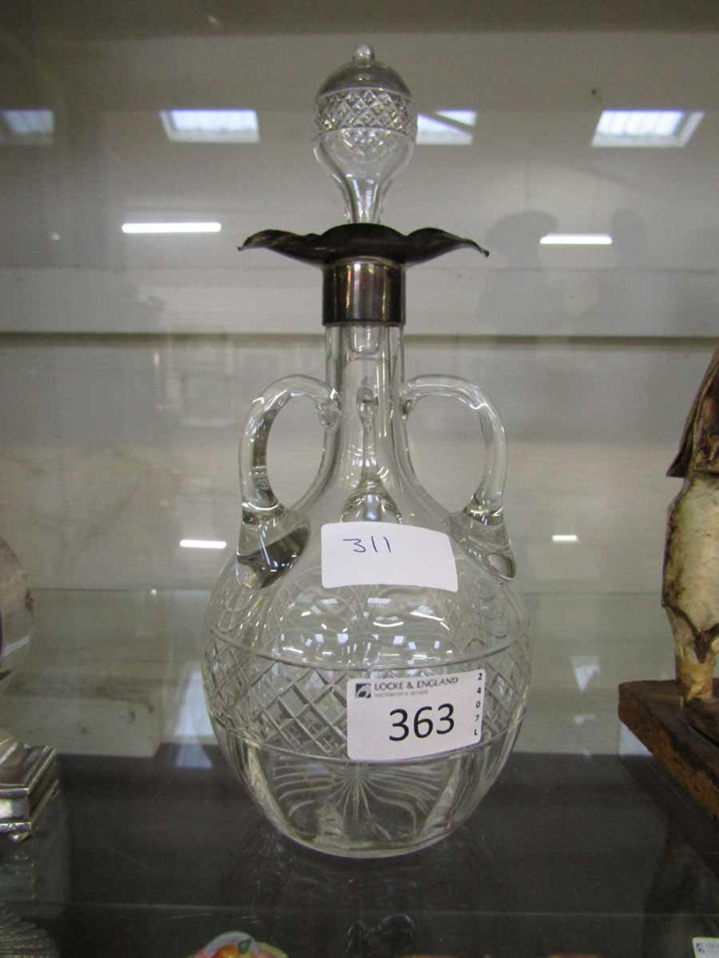 A silver hallmarked three handled cut glass decanter
