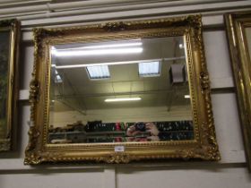 A reproduction ornate gilt framed bevel glass wall mirror