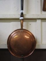 A brass and copper bed warming pan