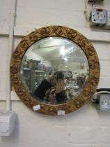 An ornate gilt framed circular bevel glass wall mirror