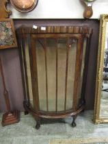 A mid-20th century mahogany veneered bow fronted glazed display cabinet on ball and claw feet