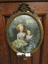 An ornate gilt framed oval print of two young children