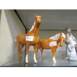 Two Beswick ceramic figurines of Palomino horses (A/F, two legs damaged to smaller)