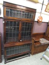 An early 20th century three tier leaded glass bookcase having a lift up top section and two doors