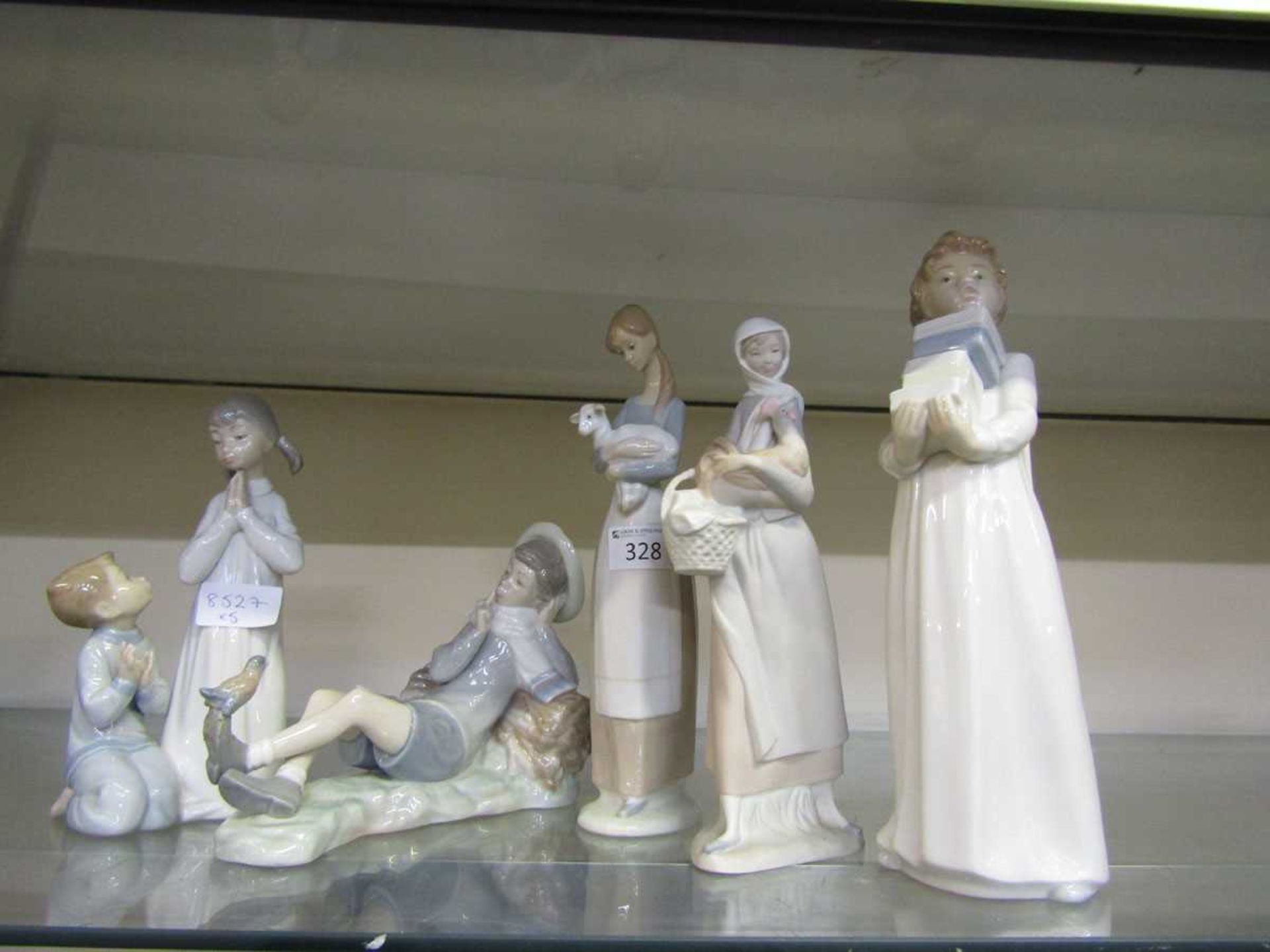 Lladro ceramic figurines along with one Nao figurine consisting of young girl and boy praying,