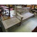 A weathered wooden garden bench together with a similar occasional table